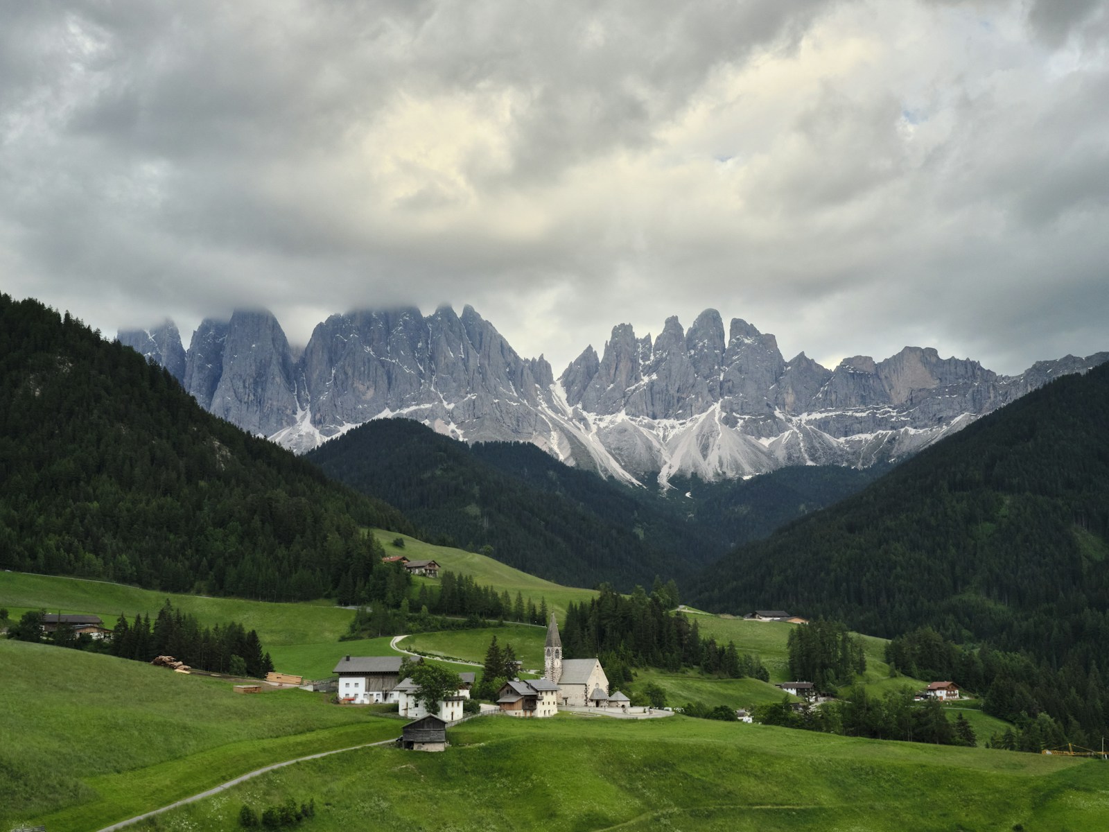 Green meadows and a village church beneath the Odle peaks in Val di Funes