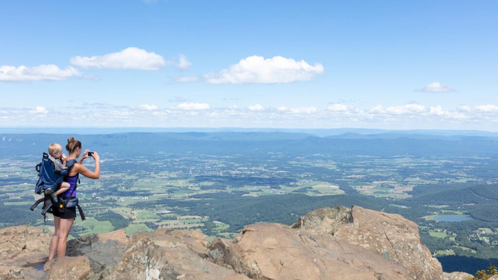 A walker looks over the forested Shenandoah ridges from Stony Man, an optional side hike near Skyland.